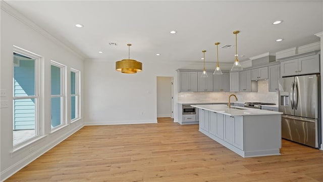 kitchen featuring a sink, decorative backsplash, gray cabinets, and stainless steel appliances