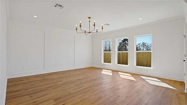 unfurnished dining area featuring light wood-type flooring, a notable chandelier, visible vents, and a decorative wall