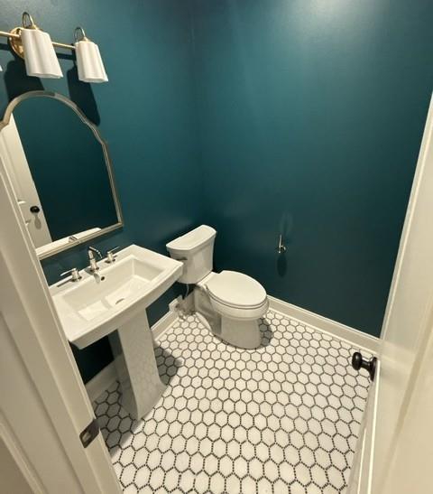 bathroom featuring baseboards and toilet