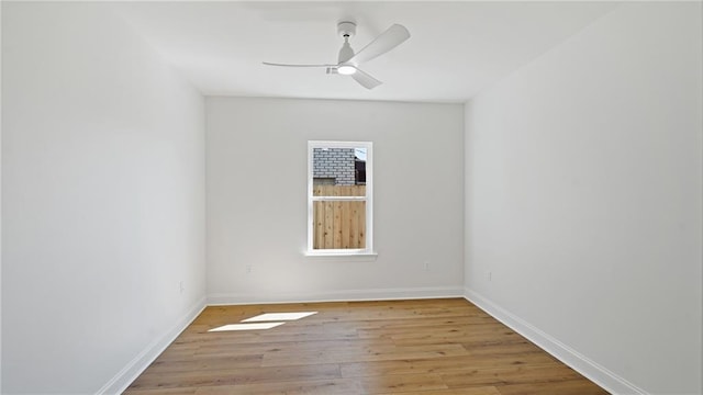 empty room with light wood finished floors, baseboards, and a ceiling fan