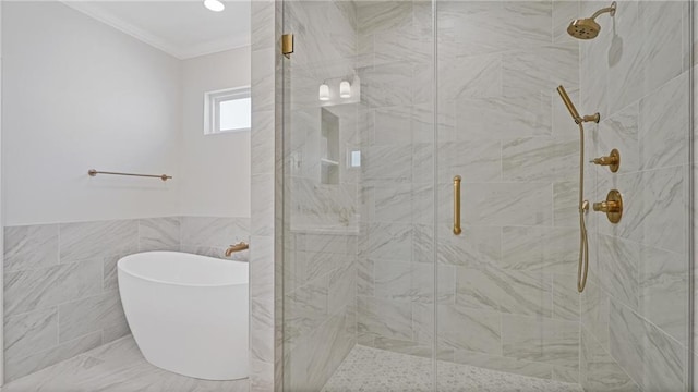 bathroom with a shower stall, a freestanding tub, tile walls, and ornamental molding