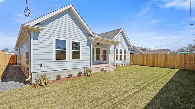 back of house featuring a yard, a fenced backyard, and ceiling fan