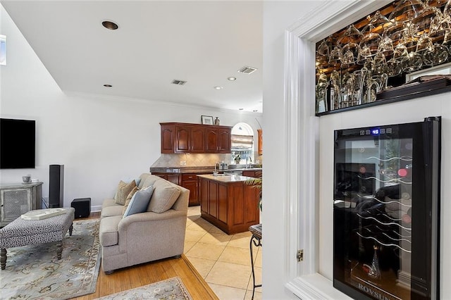 living room featuring light tile patterned floors, visible vents, recessed lighting, and ornamental molding