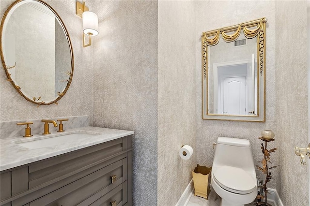 bathroom featuring vanity, toilet, visible vents, and baseboards