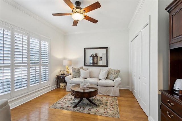 living area with light wood-style flooring, baseboards, ceiling fan, and ornamental molding