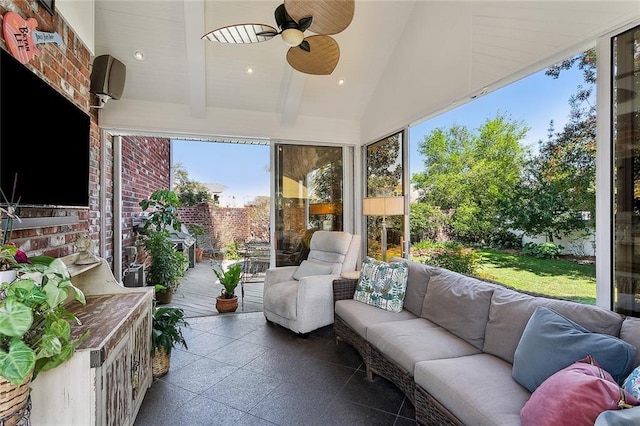 sunroom / solarium featuring lofted ceiling with beams and ceiling fan