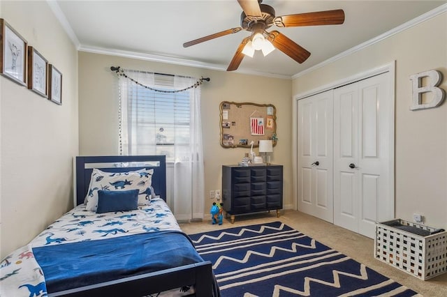 carpeted bedroom featuring a closet, baseboards, a ceiling fan, and ornamental molding