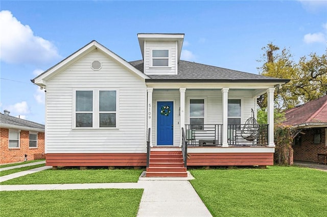 bungalow-style home with a porch, a shingled roof, and a front lawn