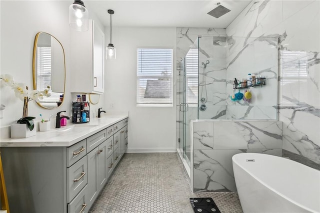 full bath with vanity, a wealth of natural light, a freestanding tub, and a marble finish shower