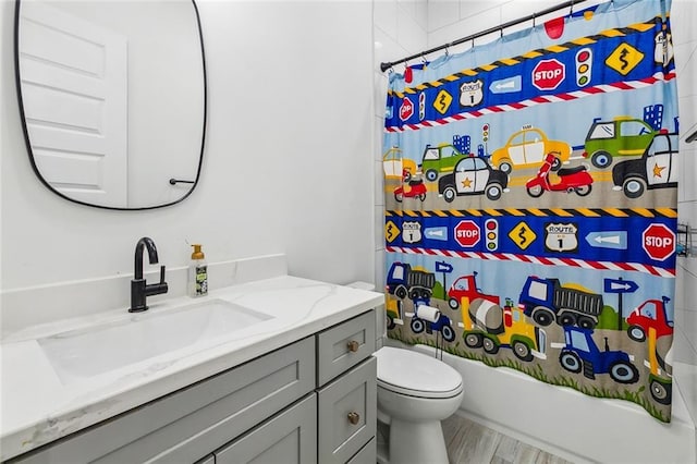 full bath featuring shower / tub combo, toilet, wood finished floors, and vanity