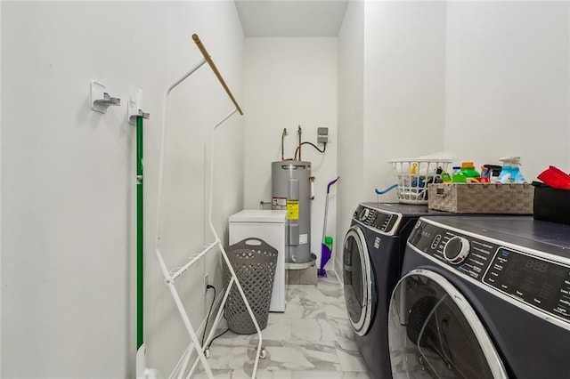 clothes washing area with separate washer and dryer, marble finish floor, water heater, and laundry area