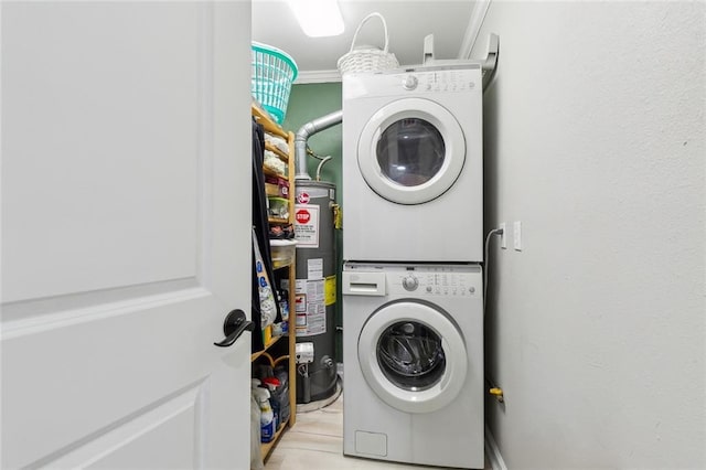 washroom featuring laundry area, gas water heater, crown molding, and stacked washer and dryer