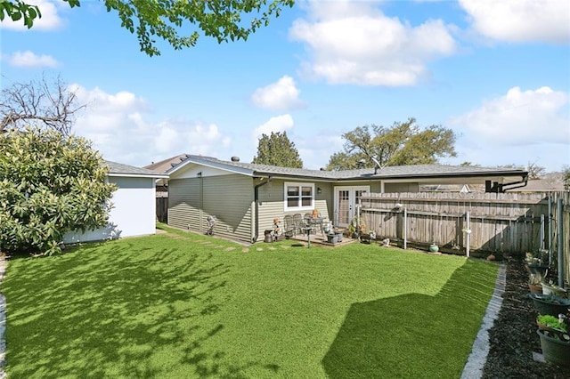 rear view of property with a lawn and fence