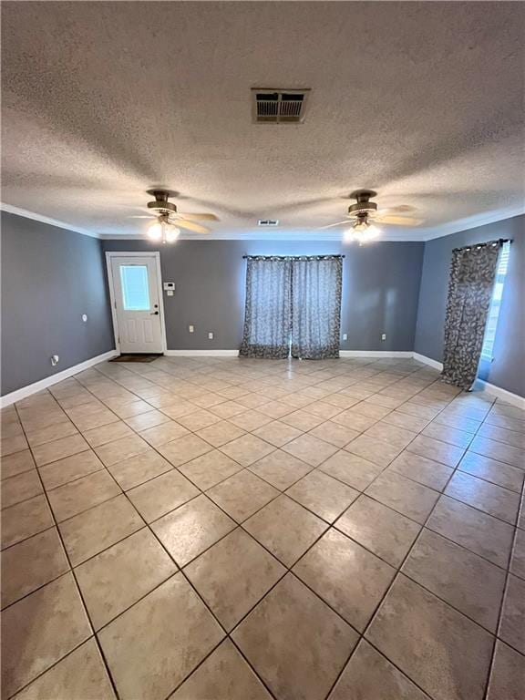 spare room with visible vents, a ceiling fan, a textured ceiling, light tile patterned floors, and baseboards