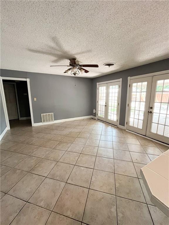 empty room featuring a wealth of natural light, french doors, and visible vents