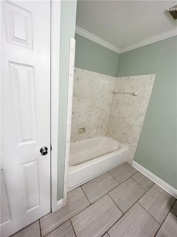 bathroom featuring visible vents, baseboards, wood tiled floor, ornamental molding, and a bathtub