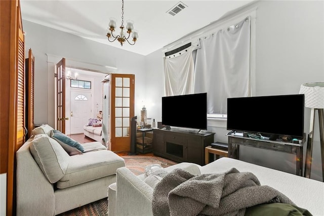 living room with a notable chandelier and visible vents