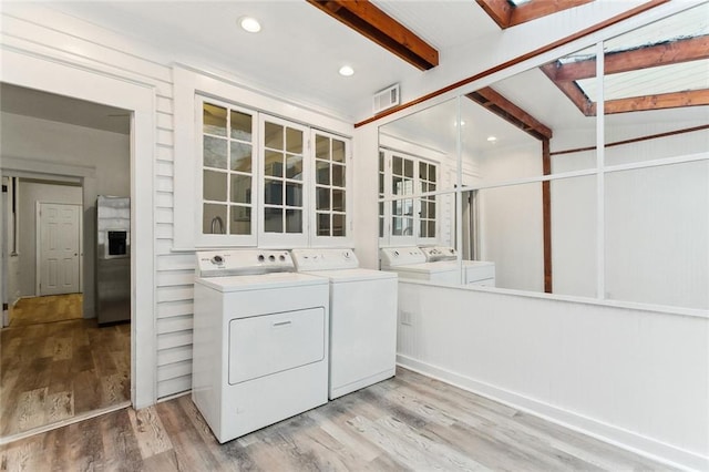 clothes washing area featuring visible vents, washing machine and dryer, recessed lighting, light wood finished floors, and laundry area