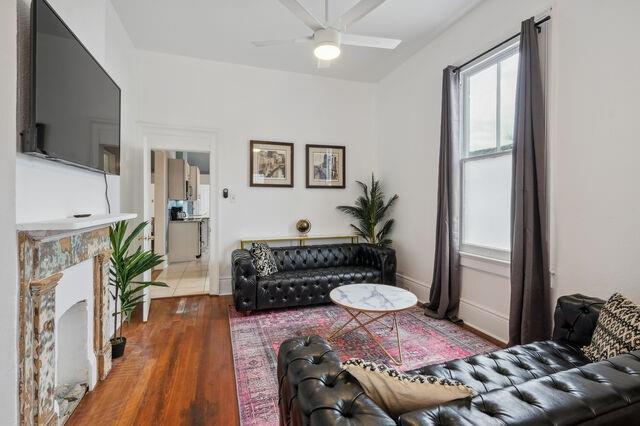 living area with ceiling fan and wood finished floors