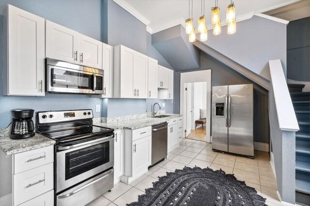 kitchen featuring white cabinetry, light tile patterned flooring, appliances with stainless steel finishes, and a sink