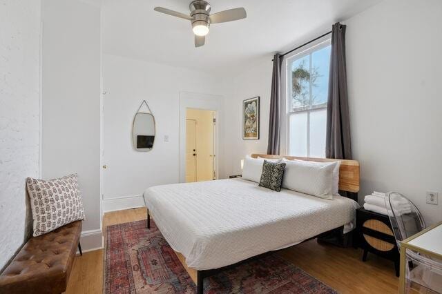 bedroom featuring wood finished floors, baseboards, and ceiling fan