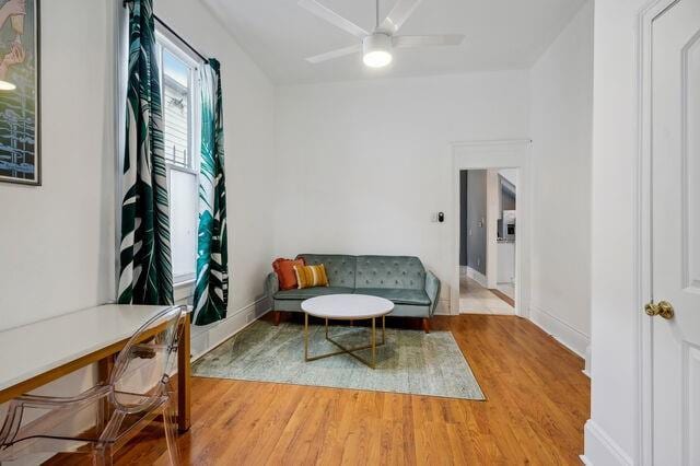 sitting room with wood finished floors, baseboards, and ceiling fan