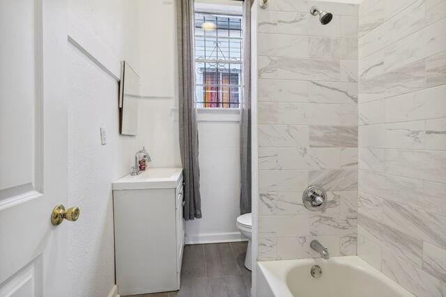 bathroom featuring toilet, wood finished floors, washtub / shower combination, baseboards, and vanity