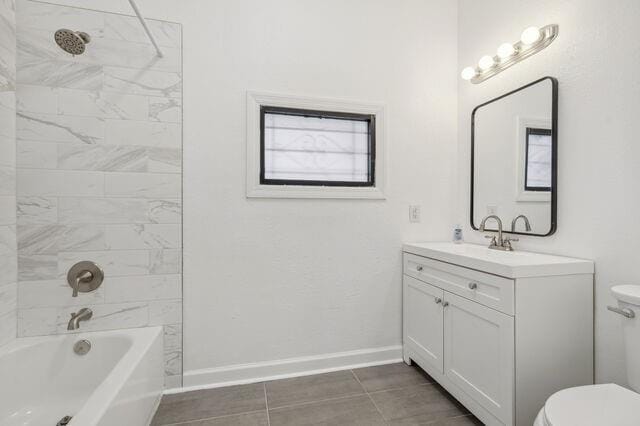 bathroom with tub / shower combination, toilet, vanity, and baseboards