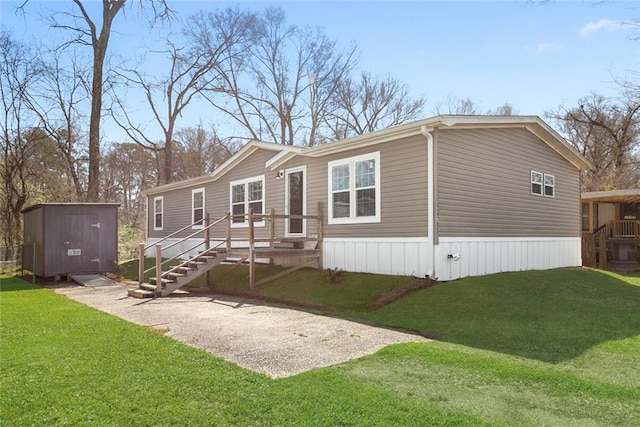 view of front of house featuring a storage shed, an outdoor structure, a front yard, and driveway