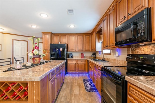 kitchen featuring visible vents, black appliances, light countertops, and a sink