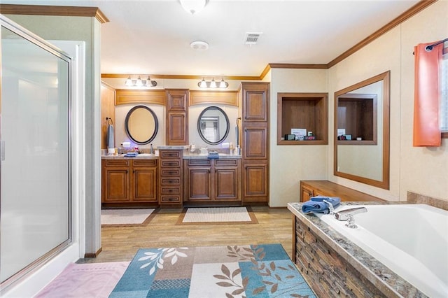 bathroom with visible vents, ornamental molding, a shower stall, double vanity, and a bath