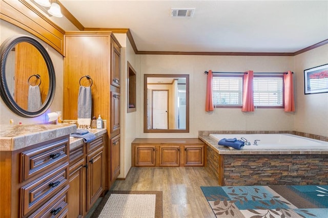 full bathroom featuring vanity, wood finished floors, visible vents, crown molding, and a bath