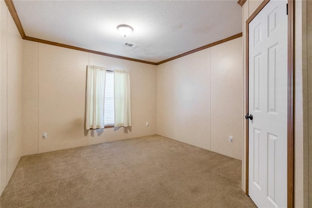 unfurnished room featuring visible vents, carpet, ornamental molding, and a textured ceiling