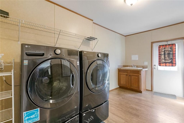 laundry room featuring a sink, ornamental molding, laundry area, and washer and clothes dryer