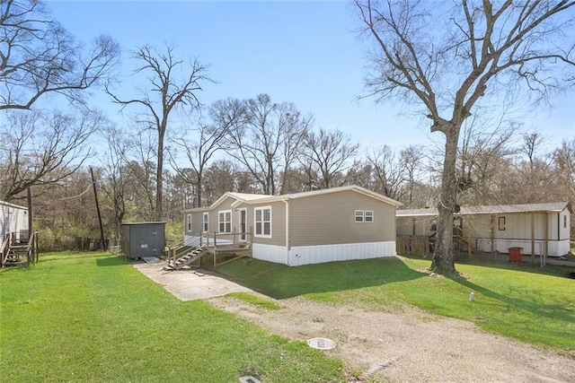 exterior space featuring a storage unit, a front yard, an outbuilding, and driveway