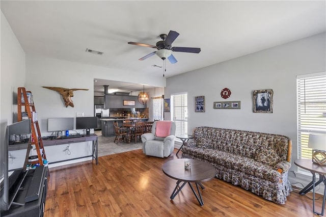 living area featuring a wealth of natural light, ceiling fan, and wood finished floors