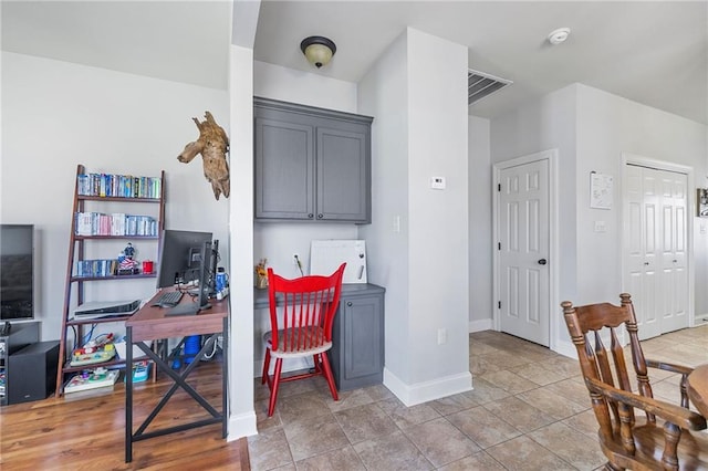 office with light tile patterned floors, visible vents, and baseboards