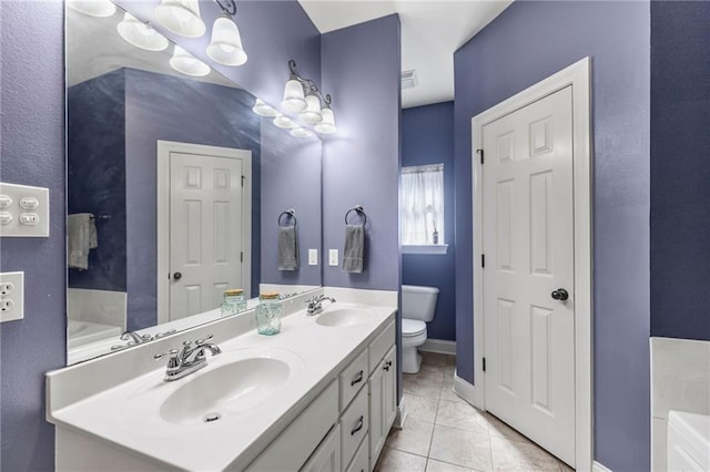 bathroom with tile patterned floors, toilet, a tub to relax in, and a sink