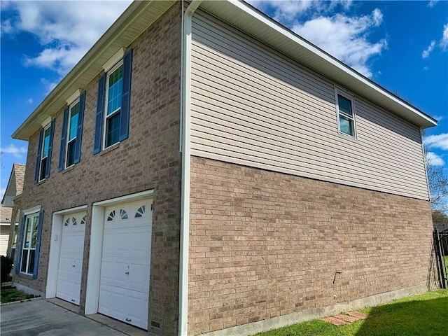 view of home's exterior featuring concrete driveway, brick siding, and a garage