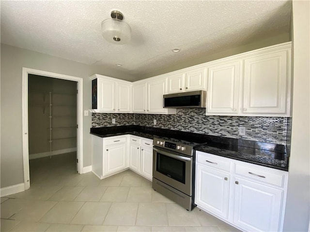 kitchen with stainless steel appliances, dark countertops, and white cabinetry