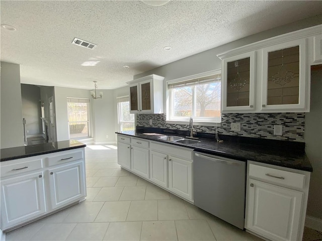 kitchen featuring a sink, glass insert cabinets, dark countertops, and dishwasher