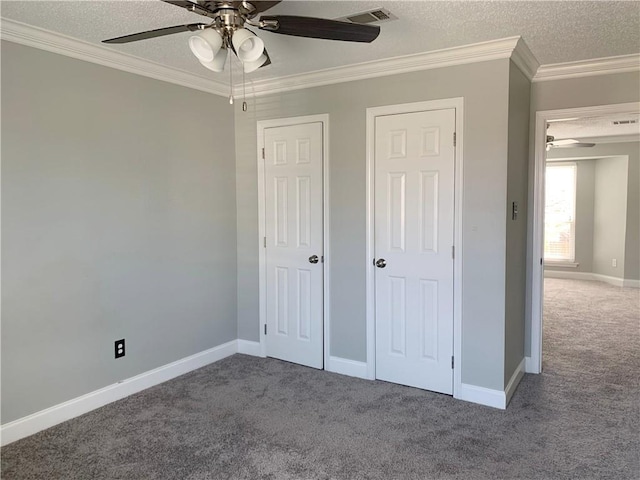 unfurnished bedroom featuring carpet flooring, a textured ceiling, crown molding, and visible vents