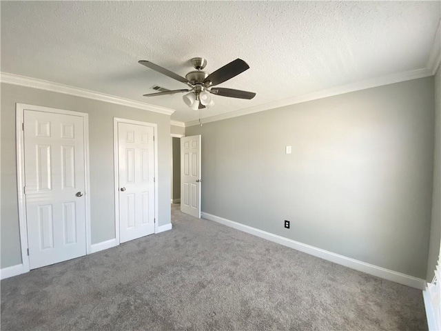 unfurnished bedroom with crown molding, carpet flooring, baseboards, and a textured ceiling