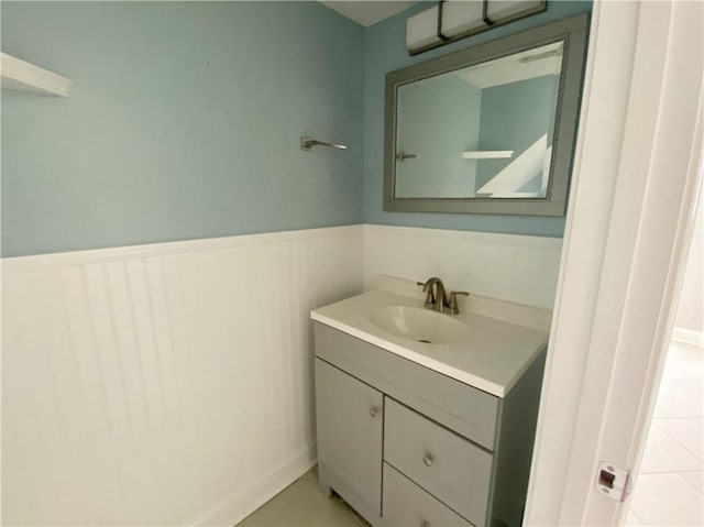 bathroom featuring vanity, tile patterned floors, and a wainscoted wall