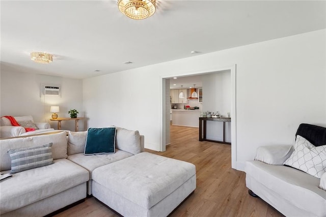 living room with an AC wall unit and wood finished floors