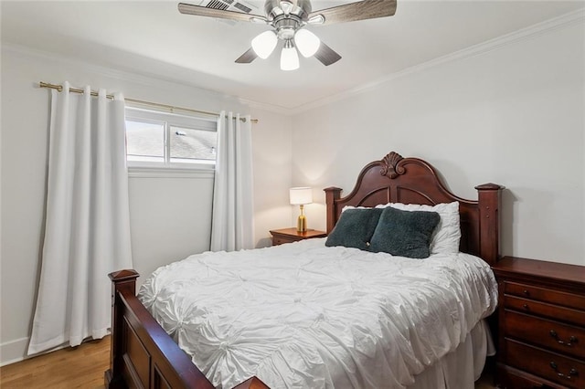 bedroom with a ceiling fan, wood finished floors, and crown molding