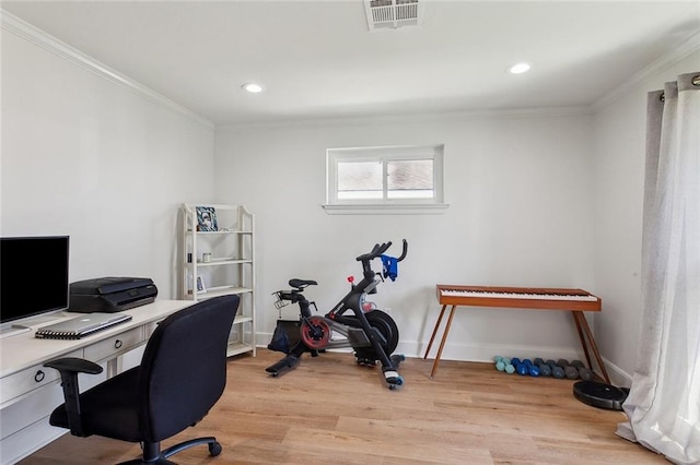 home office with visible vents, baseboards, crown molding, and light wood-style floors