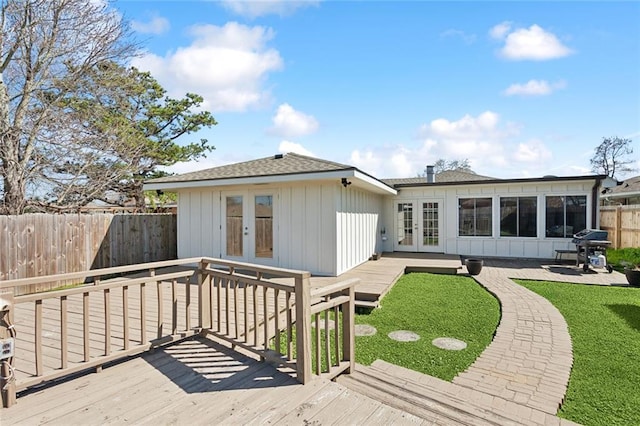 back of house featuring a fenced backyard, french doors, a deck, and board and batten siding