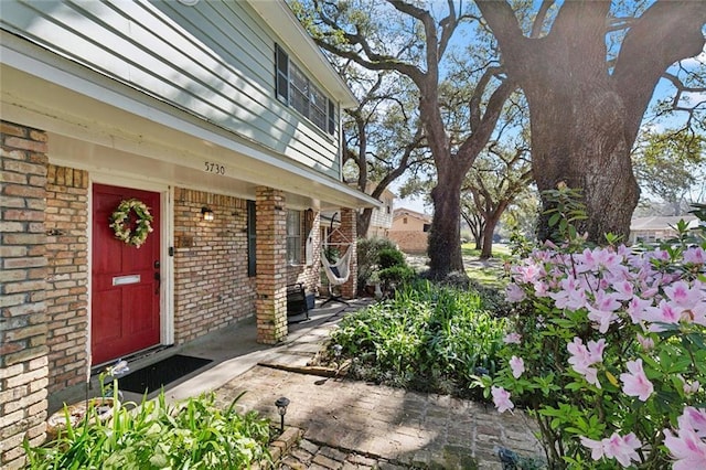 view of exterior entry with brick siding