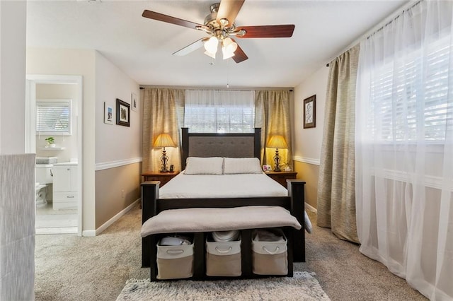 bedroom featuring carpet flooring, connected bathroom, a ceiling fan, and baseboards